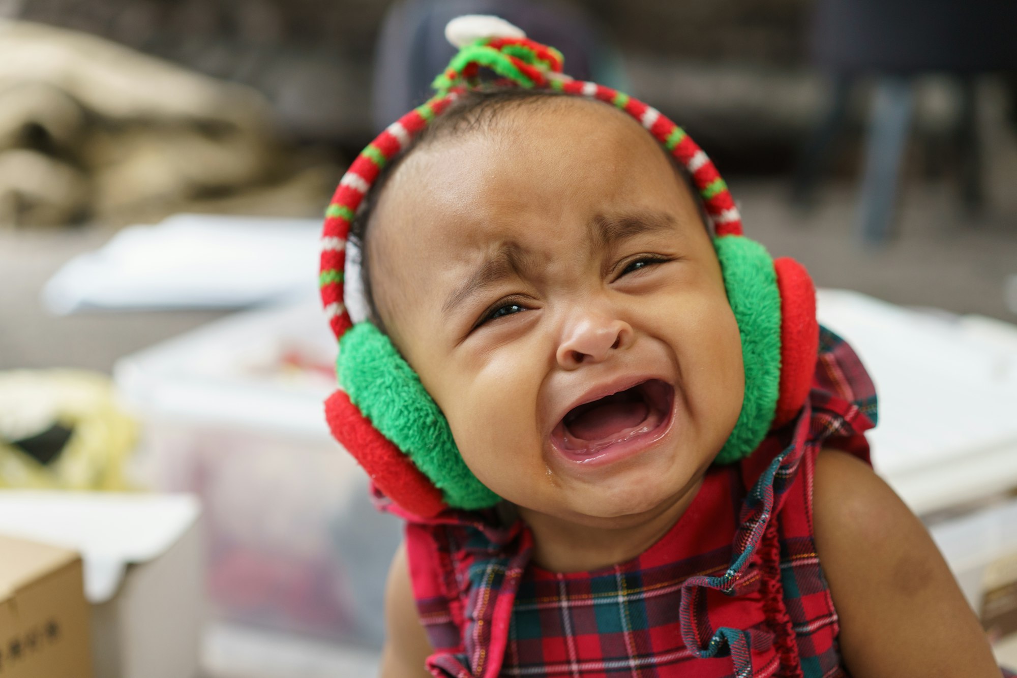 African American baby girl wearing headphone crying in the room